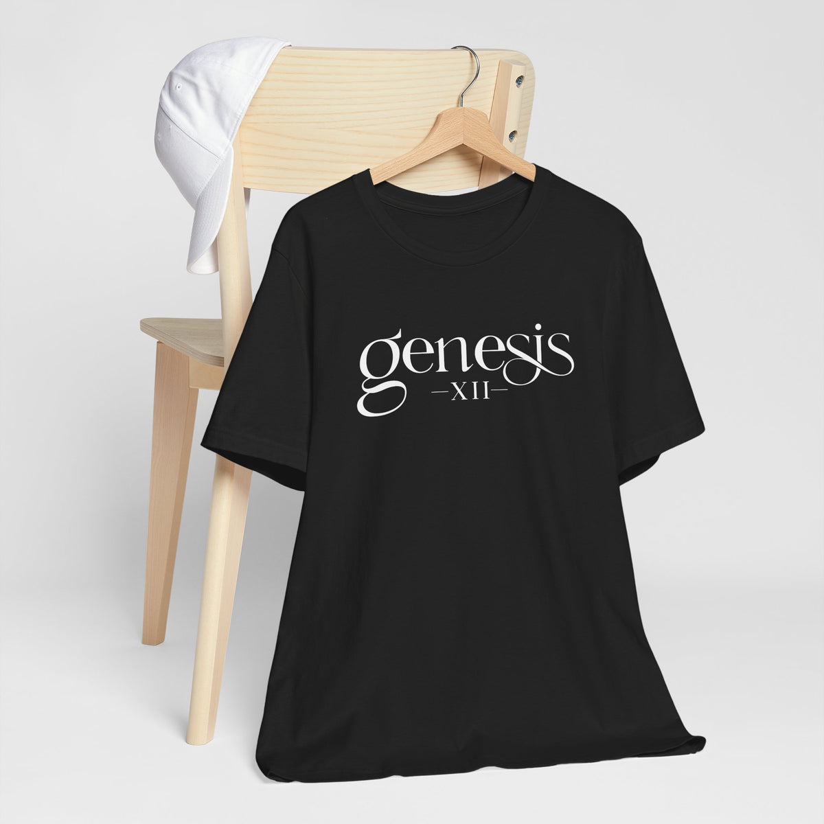 Black t-shirt with 'Genesis XII' text on a hanger against a white background