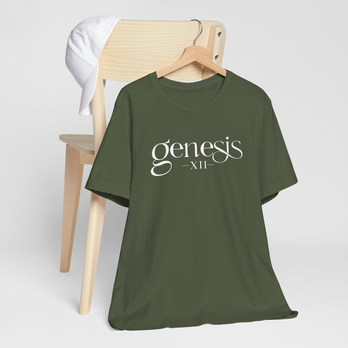 Military Green t-shirt with 'Genesis XII' design on a wooden chair against a white background